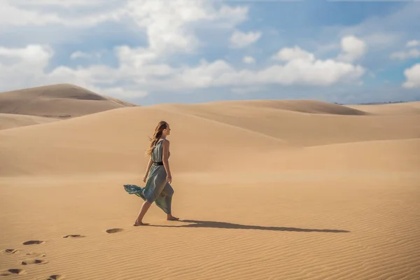 Młoda piękna kobieta podróżująca po pustyni. Piaszczyste wydmy i błękitne niebo w słoneczny letni dzień. Podróż, przygoda, koncepcja wolności. Turystyka otwiera się ponownie po kwarantannie COVID 19 — Zdjęcie stockowe