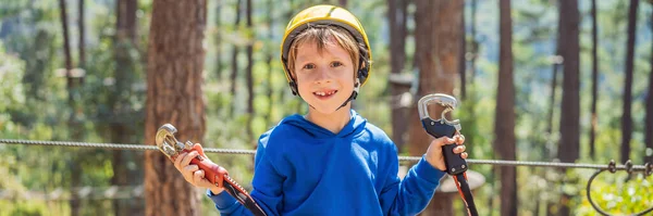 BANNER, LONG FORMAT Lyckligt barn i hjälm, frisk tonåring skolpojke njuter av aktivitet i en klättring äventyrspark på en sommardag — Stockfoto