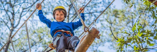 BANNER, LANG FORMAAT Gelukkig kind in een helm, gezonde tiener schooljongen genieten van activiteit in een klimpark op een zomerse dag — Stockfoto