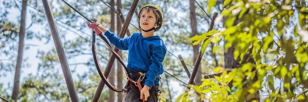 BANNER, LONG FORMAT Criança feliz em um capacete, menino de escola adolescente saudável desfrutando de atividade em um parque de aventura de escalada em um dia de verão — Fotografia de Stock