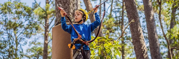 BANNER, LANG FORMAAT Gelukkig kind in een helm, gezonde tiener schooljongen genieten van activiteit in een klimpark op een zomerse dag — Stockfoto