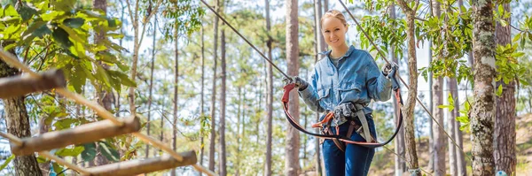 Jonge dappere vrouw klimmen in een avontuur touw park BANNER, LONG FORMAT — Stockfoto