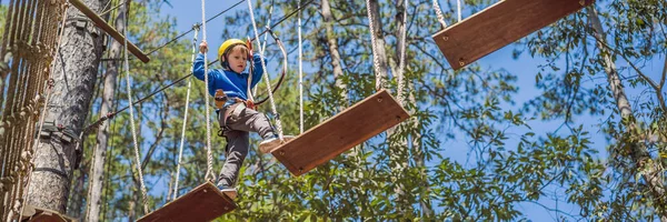 BANNER, LONG FORMAT Criança feliz em um capacete, menino de escola adolescente saudável desfrutando de atividade em um parque de aventura de escalada em um dia de verão — Fotografia de Stock
