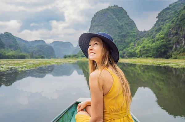 Woman tourist in boat on the lake Tam Coc, Ninh Binh, Viet nam. Its is UNESCO World Heritage Site, renowned for its boat cave tours. Its Halong Bay on land of Vietnam. Vietnam reopens borders after