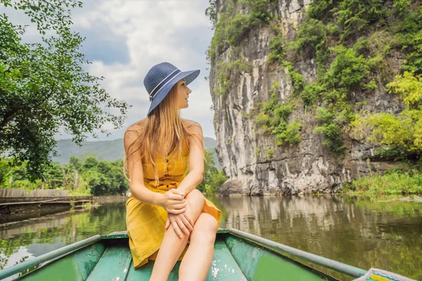 Touristin im Boot auf dem See Tam Coc, Ninh Binh, Vietnam. Es ist UNESCO-Weltkulturerbe, bekannt für seine Bootshöhlen-Touren. Seine Halong-Bucht an Land von Vietnam. Vietnam öffnet die Grenzen nach — Stockfoto