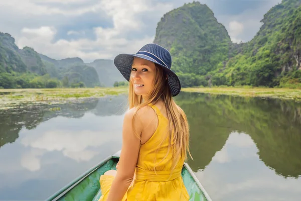 Mulher turista em barco no lago Tam Coc, Ninh Binh, Vietnã. É Património Mundial da UNESCO, conhecido por seus passeios de barco caverna. Sua baía de Halong na terra do Vietnã. Vietname reabre fronteiras após — Fotografia de Stock