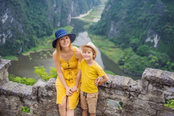 Mother and son tourists on the lake Tam Coc and pagoda of Hang Mua temple, Ninh Binh, Viet nam. Its is UNESCO World Heritage Site, renowned for its boat cave tours. Its Halong Bay on land of Vietnam — Stock Photo, Image