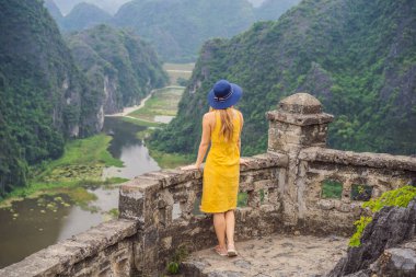 Tam Coc gölündeki kadın turist, Ninh Binh, Vietnam. UNESCO Dünya Mirası Alanı 'dır ve tekne mağarası turlarıyla ünlüdür. Vietnam topraklarındaki Halong Körfezi. Vietnam sonra sınırları yeniden açıyor