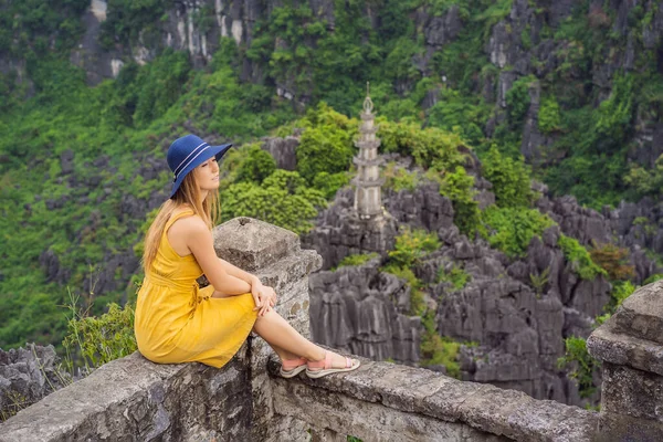 Hang Mua Tapınağı 'nın tepesindeki kadın turist, pirinç tarlaları, Ninh Binh, Vietnam. Vietnam, Coronovirus COVID 19 karantinasından sonra sınırları yeniden açıyor.