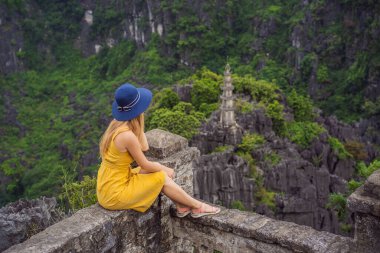 Hang Mua Tapınağı 'nın tepesindeki kadın turist, pirinç tarlaları, Ninh Binh, Vietnam. Vietnam, Coronovirus COVID 19 karantinasından sonra sınırları yeniden açıyor.