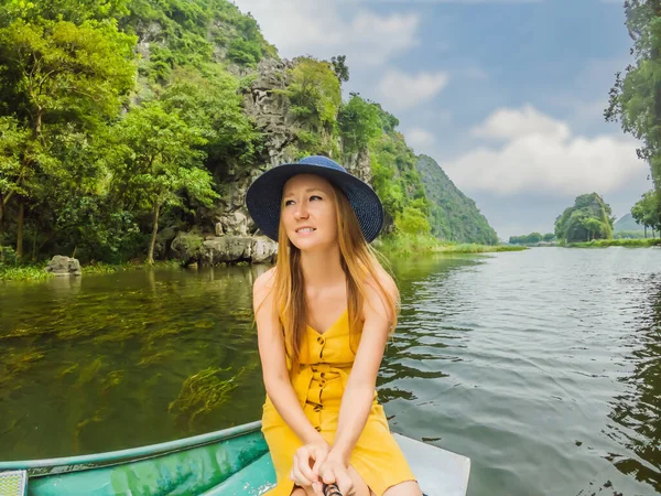 Mulher turista em barco no lago Tam Coc, Ninh Binh, Vietnã. É Património Mundial da UNESCO, conhecido por seus passeios de barco caverna. Sua baía de Halong na terra do Vietnã. Vietname reabre fronteiras após — Fotografia de Stock