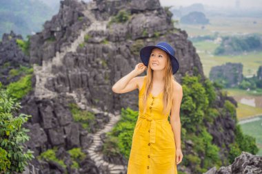 Hang Mua Tapınağı 'nın tepesindeki kadın turist, pirinç tarlaları, Ninh Binh, Vietnam. Vietnam, Coronovirus COVID 19 karantinasından sonra sınırları yeniden açıyor.