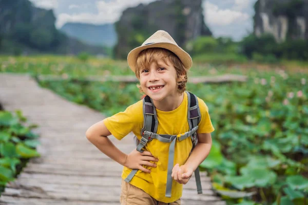 Niño en un amarillo en el camino entre el lago de loto. Cueva de Mua, Ninh Binh, Vietnam. Vietnam reabre tras cuarentena concepto de Coronovirus COVID 19 — Foto de Stock