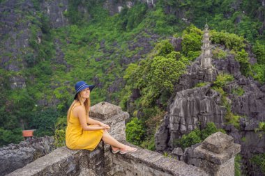 Hang Mua Tapınağı 'nın tepesindeki kadın turist, pirinç tarlaları, Ninh Binh, Vietnam. Vietnam, Coronovirus COVID 19 karantinasından sonra sınırları yeniden açıyor.