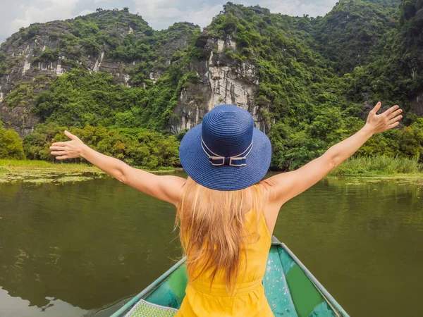 Женщина-туристка в лодке на озере Там Кок, Нин Бинь, Вьетнам. Он является объектом Всемирного наследия ЮНЕСКО, известным своими экскурсиями по пещерам на лодках. Его залив Халонг на земле Вьетнама. Вьетнам вновь открывает границы после — стоковое фото
