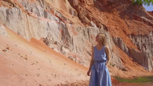 Een vrouw loopt langs een rode canyon of Fairy beek op de grens van de woestijn in het Mui Ne dorp in het zuiden van Vietnam — Stockvideo