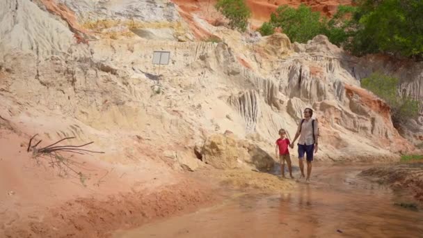 南ベトナムのムイネ村の砂漠の境界にある赤い峡谷や妖精のストリームに沿って家族が歩く — ストック動画