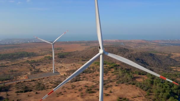 Tiro aéreo de um grupo de turbinas eólicas em um ambiente semideserto. Conceito de energia verde — Vídeo de Stock