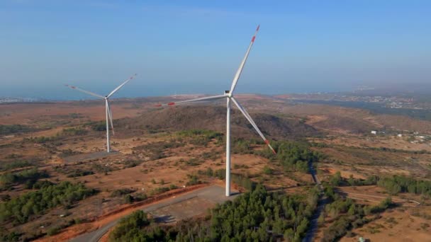 Tiro aéreo de um grupo de turbinas eólicas em um ambiente semideserto. Conceito de energia verde — Vídeo de Stock