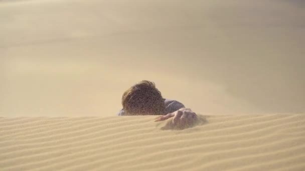 Egy férfi egy irodai ruhában felmászik egy dűnén a sivatagban. Az üzleti kihívások leküzdése — Stock videók