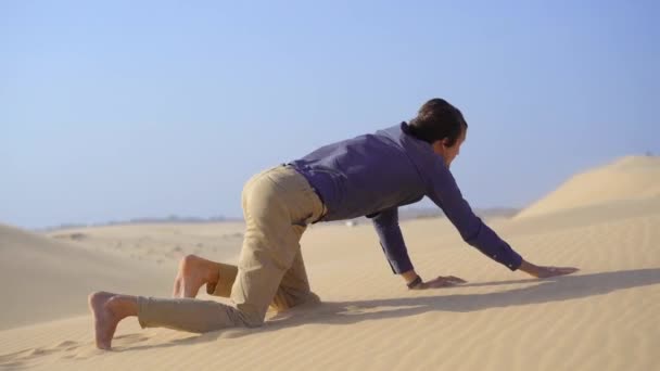 Un uomo in un panno da ufficio striscia in un deserto e alla fine muore. Problemi nella vita — Video Stock