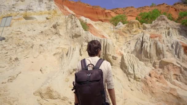 Um turista homem visita o desfiladeiro vermelho ou fluxo de fadas na fronteira do deserto na aldeia Mui Ne, no sul do Vietnã — Vídeo de Stock