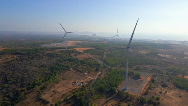 Tiro aéreo de um grupo de turbinas eólicas em um ambiente semideserto. Conceito de energia verde — Vídeo de Stock