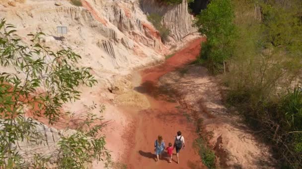 Luchtfoto slow motion. Een familie wandelingen langs een rode canyon of Fairy beek op de grens van de woestijn in de Mui Ne dorp in het zuiden van Vietnam — Stockvideo