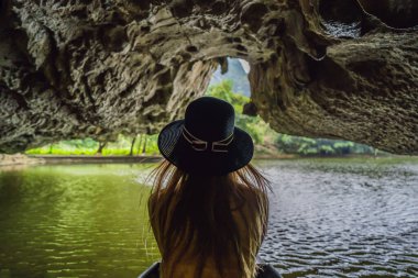 Tam Coc gölündeki kadın turist, Ninh Binh, Vietnam. UNESCO Dünya Mirası Alanı 'dır ve tekne mağarası turlarıyla ünlüdür. Vietnam topraklarındaki Halong Körfezi. Vietnam sonra sınırları yeniden açıyor
