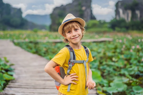 Niño en un amarillo en el camino entre el lago de loto. Cueva de Mua, Ninh Binh, Vietnam. Vietnam reabre tras cuarentena concepto de Coronovirus COVID 19 — Foto de Stock