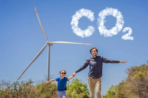 Minskade CO2-nivåer. Diagram över minskningen av koldioxidnivåerna. Alternativ energi, vindkraftspark och lycklig tid med familjen. Lycklig far på vägen med sin son på semester och fly till — Stockfoto