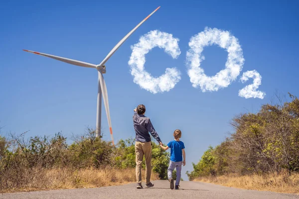 Minskade CO2-nivåer. Diagram över minskningen av koldioxidnivåerna. Alternativ energi, vindkraftspark och lycklig tid med familjen. Lycklig far på vägen med sin son på semester och fly till — Stockfoto