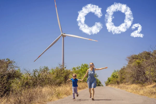 Minskade CO2-nivåer. Diagram över minskningen av koldioxidnivåerna. Alternativ energi, vindkraftspark och lycklig tid med familjen. Lycklig mor på vägen med sin son på semester och fly till — Stockfoto