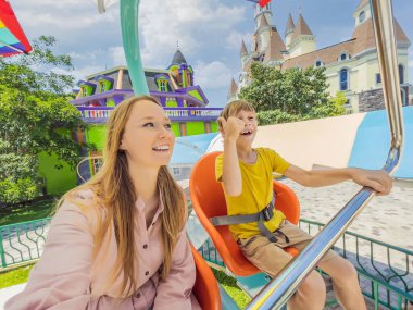 Gülümseyen oğluyla annesi lunaparkta birlikte vakit geçiriyorlar.