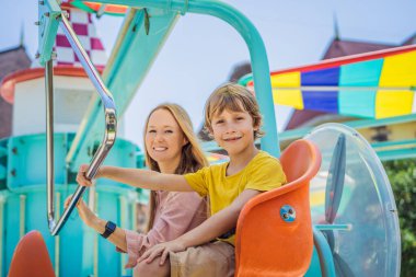 Gülümseyen oğluyla annesi lunaparkta birlikte vakit geçiriyorlar.