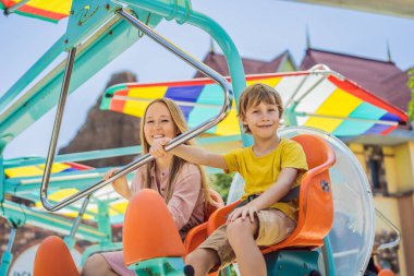 Gülümseyen oğluyla annesi lunaparkta birlikte vakit geçiriyorlar.