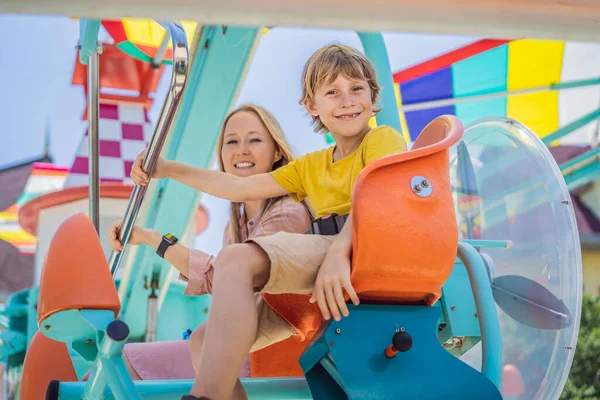 Happy smiling son and his mother spending fun time together at amusement park — Stock Photo, Image