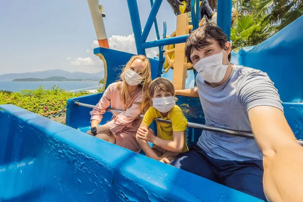 Family wearing a medical mask during COVID-19 coronavirus at an amusement park — Stock Photo, Image