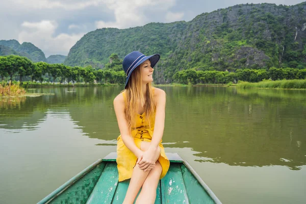 Mulher turista em barco no lago Tam Coc, Ninh Binh, Vietnã. É Património Mundial da UNESCO, conhecido por seus passeios de barco caverna. Sua baía de Halong na terra do Vietnã. Vietname reabre fronteiras após — Fotografia de Stock