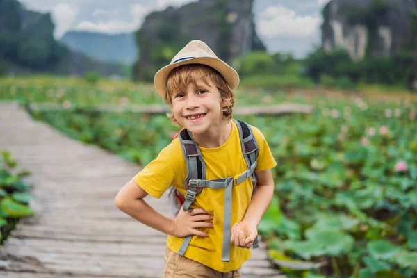 Niño en un amarillo en el camino entre el lago de loto. Cueva de Mua, Ninh Binh, Vietnam. Vietnam reabre tras cuarentena concepto de Coronovirus COVID 19 — Foto de Stock