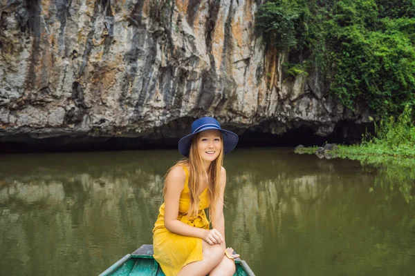 Woman tourist in boat on the lake Tam Coc, Ninh Binh, Viet nam. Its is UNESCO World Heritage Site, renowned for its boat cave tours. Its Halong Bay on land of Vietnam. Vietnam reopens borders after