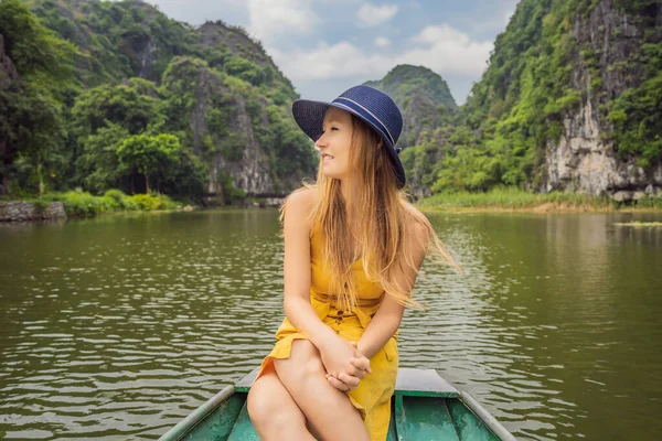 Woman tourist in boat on the lake Tam Coc, Ninh Binh, Viet nam. Its is UNESCO World Heritage Site, renowned for its boat cave tours. Its Halong Bay on land of Vietnam. Vietnam reopens borders after