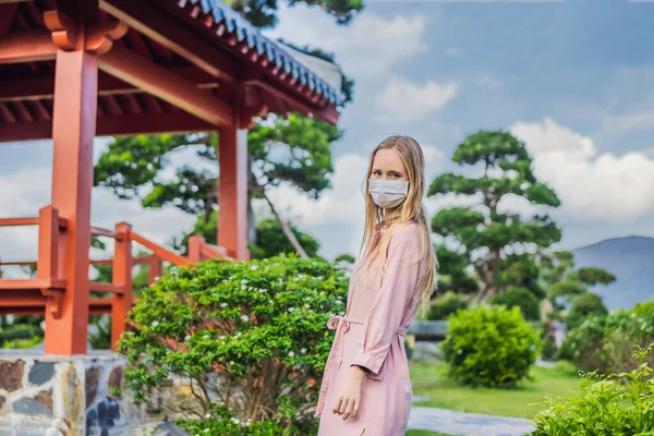 Femme voyageuse en masque médical regardant le bâtiment traditionnel japonais. Les touristes voyagent au Japon après l'épidémie de coronavirus — Photo