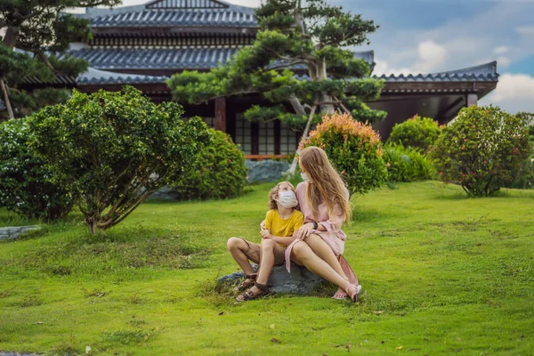 Мати і син подорожують по медичній масці, дивлячись на японський традиційний будинок. Туристи подорожують по Японії після епідемії коронавірусу. — стокове фото