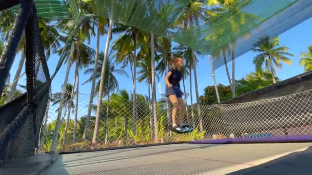 Langsomt skud. En ung kvinde morer sig i en trampolin park i troperne. Skudt på en telefon – Stock-video