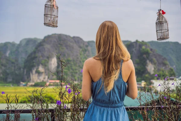 Donna beve caffè al mattino sullo sfondo delle colline in Ninh Binh, Tam Coc. Ripresa del turismo in Vietnam dopo la quarantena Coronovirus COVID 19 — Foto Stock