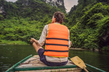 Ninh Binh Eyaleti, Vietnam 'daki Trang An Manzara Kompleksindeki Erkek Turist UNESCO Dünya Mirası Bölgesi. Coronovirus COVID 19 karantinasından sonra Vietnam 'da turizmin devamı