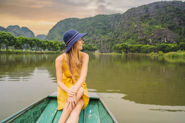 Woman tourist in boat on the lake Tam Coc, Ninh Binh, Viet nam. Its is UNESCO World Heritage Site, renowned for its boat cave tours. Its Halong Bay on land of Vietnam. Vietnam reopens borders after