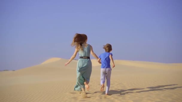 Fotografía en cámara lenta de una joven mujer y un niño divirtiéndose en un desierto — Vídeos de Stock