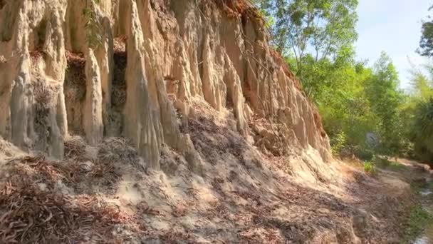 Disparo en cámara lenta. Una familia camina a lo largo de un cañón rojo o arroyo de hadas en la frontera del desierto en el pueblo de Mui Ne en el sur de Vietnam. Disparo en un teléfono — Vídeos de Stock